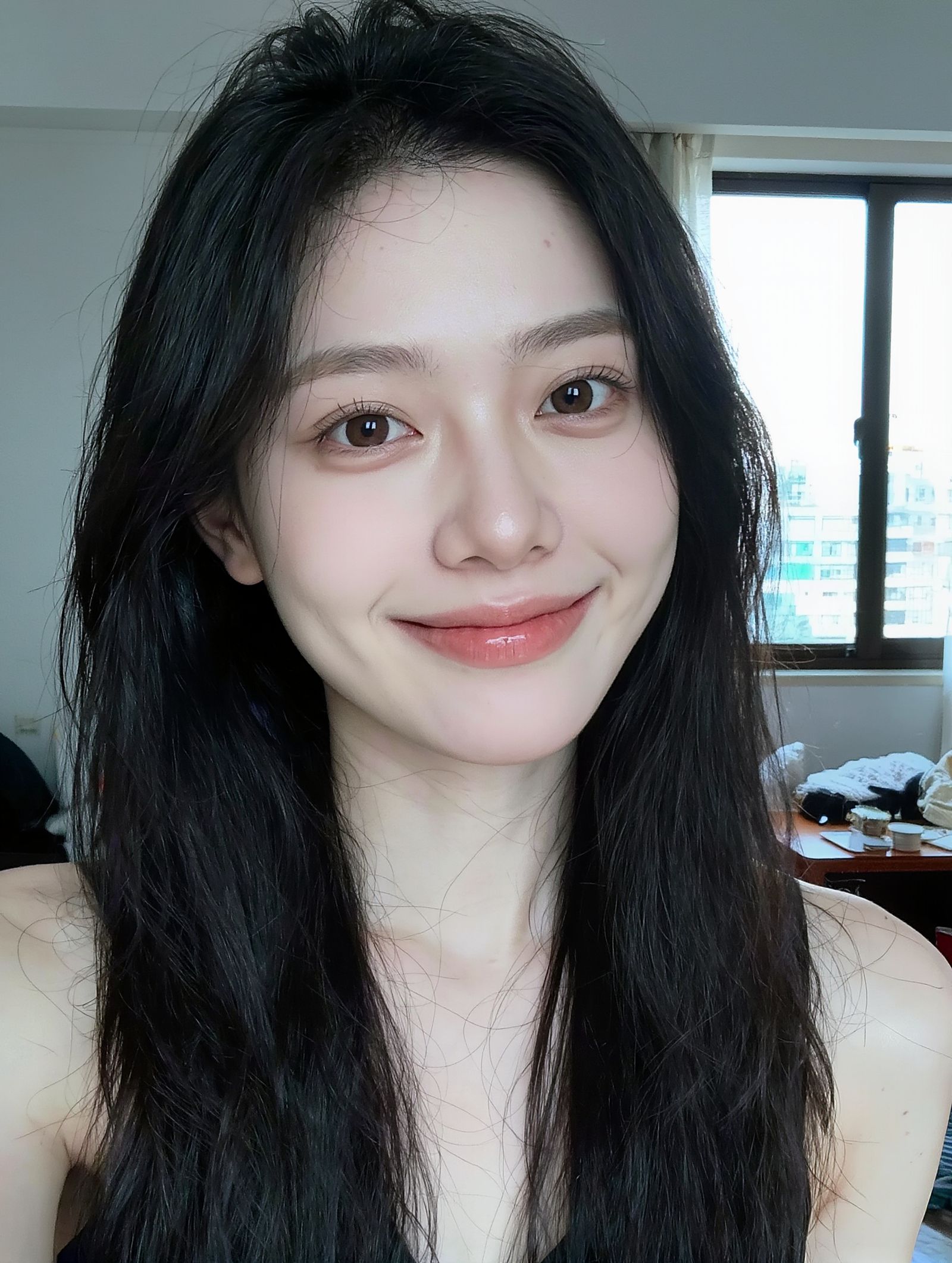 Smiling young Korean woman with long dark hair taking a selfie by a window in a Taipei apartment